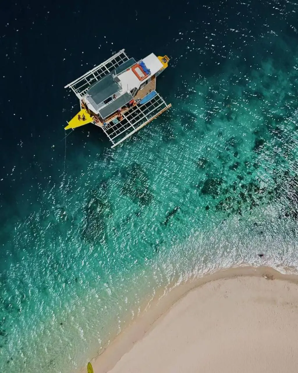 Beach with boats moored off the Palawan coast